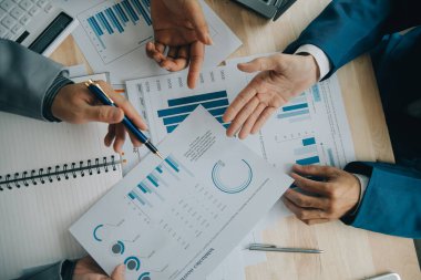 Finansal analistler, şirketlerin başarılı takım çalışmalarının sonuçlarını gösteren bir toplantıda bir dijital tablet planlama yatırım projesinin ticari mali raporlarını analiz ediyorlar..