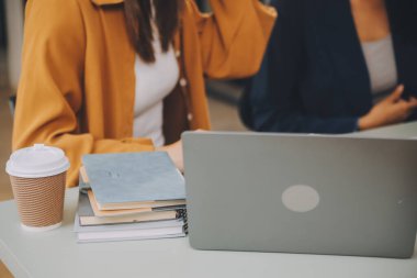 Dizüstü bilgisayarda çalışan Asyalı iş kadını online iş ara, masadaki not defterine bak ve daktilo yaz, online öğrenim gören kadın yaşam tarzı