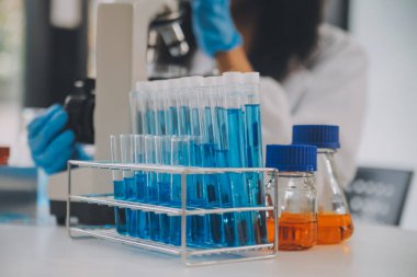 Coronavirus aşısı geliştirmek için mikroskop ile çalışan biyokimyasal araştırma ekibi farmasötik araştırma laboratuvarında, seçici odaklı