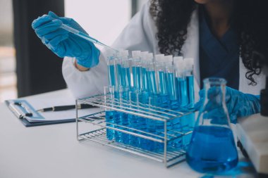 Coronavirus aşısı geliştirmek için mikroskop ile çalışan biyokimyasal araştırma ekibi farmasötik araştırma laboratuvarında, seçici odaklı