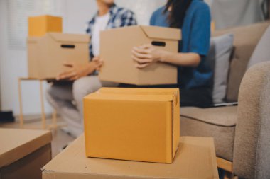 İki Asyalı blogcu, dükkanında canlı yayın yapan videoyu kaydetmek için kameranın önünde kıyafetlerini gösteriyor. Çevrimiçi alışveriş arabası fikri. Evdeki kanepede.