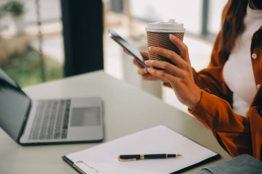 Dizüstü bilgisayarda çalışan Asyalı iş kadını online iş ara, masadaki not defterine bak ve daktilo yaz, online öğrenim gören kadın yaşam tarzı