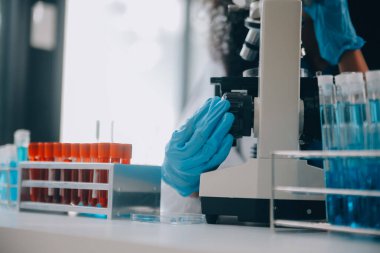 Coronavirus aşısı geliştirmek için mikroskop ile çalışan biyokimyasal araştırma ekibi farmasötik araştırma laboratuvarında, seçici odaklı