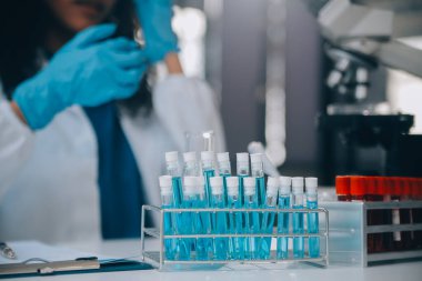 Coronavirus aşısı geliştirmek için mikroskop ile çalışan biyokimyasal araştırma ekibi farmasötik araştırma laboratuvarında, seçici odaklı