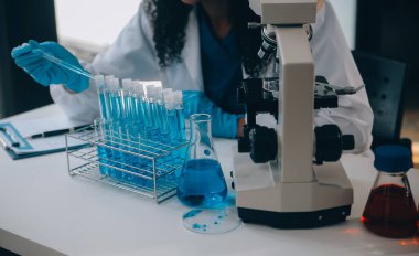 Coronavirus aşısı geliştirmek için mikroskop ile çalışan biyokimyasal araştırma ekibi farmasötik araştırma laboratuvarında, seçici odaklı