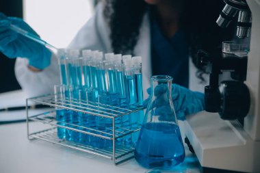 Coronavirus aşısı geliştirmek için mikroskop ile çalışan biyokimyasal araştırma ekibi farmasötik araştırma laboratuvarında, seçici odaklı