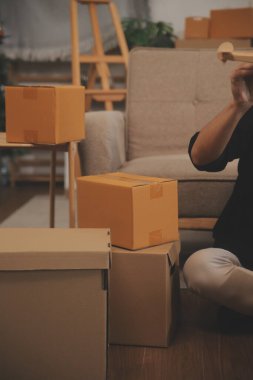 İki Asyalı blogcu, dükkanında canlı yayın yapan videoyu kaydetmek için kameranın önünde kıyafetlerini gösteriyor. Çevrimiçi alışveriş arabası fikri. Evdeki kanepede.