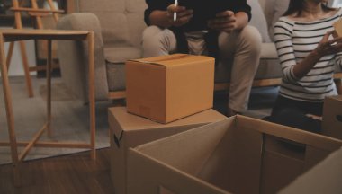 İki Asyalı blogcu, dükkanında canlı yayın yapan videoyu kaydetmek için kameranın önünde kıyafetlerini gösteriyor. Çevrimiçi alışveriş arabası fikri. Evdeki kanepede.