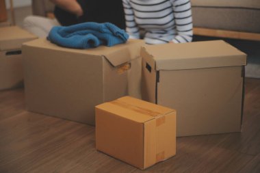 İki Asyalı blogcu, dükkanında canlı yayın yapan videoyu kaydetmek için kameranın önünde kıyafetlerini gösteriyor. Çevrimiçi alışveriş arabası fikri. Evdeki kanepede.