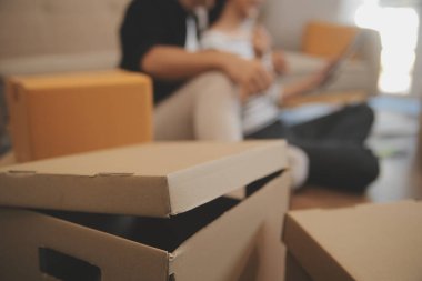 İki Asyalı blogcu, dükkanında canlı yayın yapan videoyu kaydetmek için kameranın önünde kıyafetlerini gösteriyor. Çevrimiçi alışveriş arabası fikri. Evdeki kanepede.