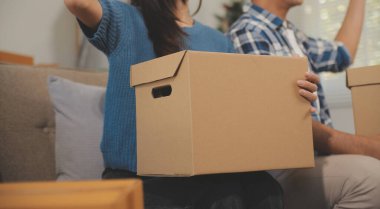 İki Asyalı blogcu, dükkanında canlı yayın yapan videoyu kaydetmek için kameranın önünde kıyafetlerini gösteriyor. Çevrimiçi alışveriş arabası fikri. Evdeki kanepede.