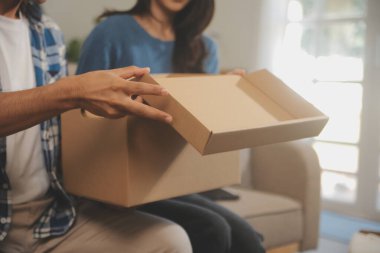 İki Asyalı blogcu, dükkanında canlı yayın yapan videoyu kaydetmek için kameranın önünde kıyafetlerini gösteriyor. Çevrimiçi alışveriş arabası fikri. Evdeki kanepede.