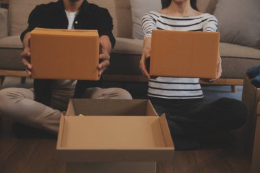 İki Asyalı blogcu, dükkanında canlı yayın yapan videoyu kaydetmek için kameranın önünde kıyafetlerini gösteriyor. Çevrimiçi alışveriş arabası fikri. Evdeki kanepede.