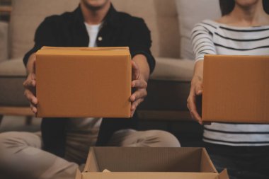 İki Asyalı blogcu, dükkanında canlı yayın yapan videoyu kaydetmek için kameranın önünde kıyafetlerini gösteriyor. Çevrimiçi alışveriş arabası fikri. Evdeki kanepede.