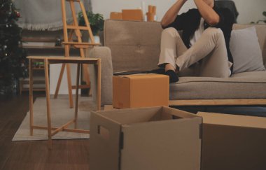 İki Asyalı blogcu, dükkanında canlı yayın yapan videoyu kaydetmek için kameranın önünde kıyafetlerini gösteriyor. Çevrimiçi alışveriş arabası fikri. Evdeki kanepede.