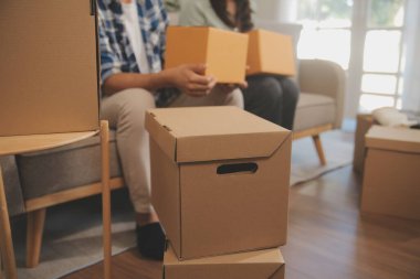 İki Asyalı blogcu, dükkanında canlı yayın yapan videoyu kaydetmek için kameranın önünde kıyafetlerini gösteriyor. Çevrimiçi alışveriş arabası fikri. Evdeki kanepede.