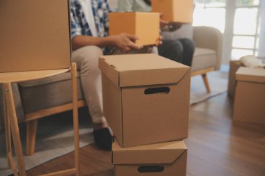 İki Asyalı blogcu, dükkanında canlı yayın yapan videoyu kaydetmek için kameranın önünde kıyafetlerini gösteriyor. Çevrimiçi alışveriş arabası fikri. Evdeki kanepede.