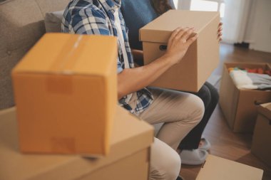 İki Asyalı blogcu, dükkanında canlı yayın yapan videoyu kaydetmek için kameranın önünde kıyafetlerini gösteriyor. Çevrimiçi alışveriş arabası fikri. Evdeki kanepede.