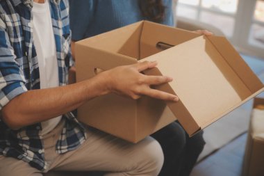 İki Asyalı blogcu, dükkanında canlı yayın yapan videoyu kaydetmek için kameranın önünde kıyafetlerini gösteriyor. Çevrimiçi alışveriş arabası fikri. Evdeki kanepede.