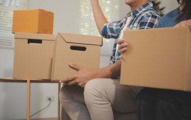 İki Asyalı blogcu, dükkanında canlı yayın yapan videoyu kaydetmek için kameranın önünde kıyafetlerini gösteriyor. Çevrimiçi alışveriş arabası fikri. Evdeki kanepede.