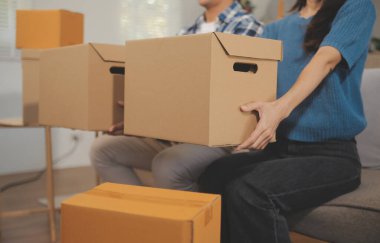 İki Asyalı blogcu, dükkanında canlı yayın yapan videoyu kaydetmek için kameranın önünde kıyafetlerini gösteriyor. Çevrimiçi alışveriş arabası fikri. Evdeki kanepede.