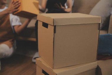 İki Asyalı blogcu, dükkanında canlı yayın yapan videoyu kaydetmek için kameranın önünde kıyafetlerini gösteriyor. Çevrimiçi alışveriş arabası fikri. Evdeki kanepede.