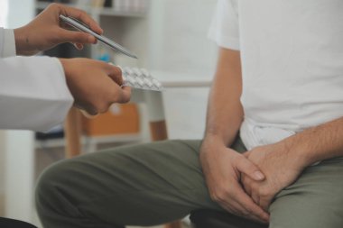 Erkek hastalıkları. Adam ellerini kasıklarına bastırıyor ve acı çekiyor. Panorama, kesilmiş, stüdyo çekimi.