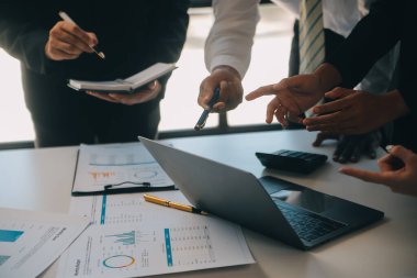 İş ekibi ile yeni başlangıç planı ve tartışma için proje bilgilerini dizüstü bilgisayar ve dijital tablet ile mali strateji bir modern iş salonda çalışıyor.