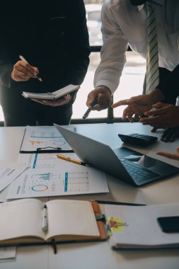 İş ekibi ile yeni başlangıç planı ve tartışma için proje bilgilerini dizüstü bilgisayar ve dijital tablet ile mali strateji bir modern iş salonda çalışıyor.