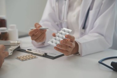 Healthcare service and pharmacy worker with customer at store counter for medication explanation. Pharmaceutical advice and opinion of pharmacist helping girl with medicine information.