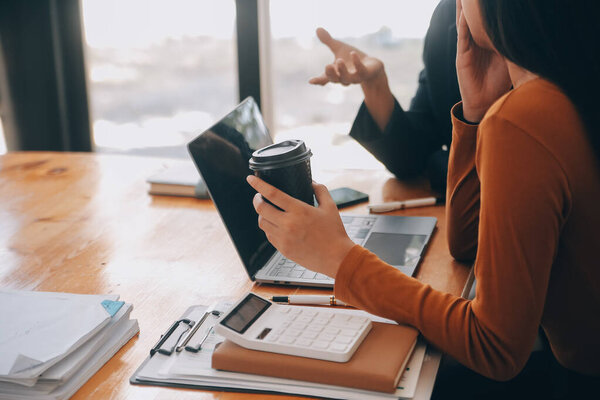 Успешная бизнес-группа празднует и надеется на цифровой планшет вместе на встрече. Люди поднимают оружие.
.