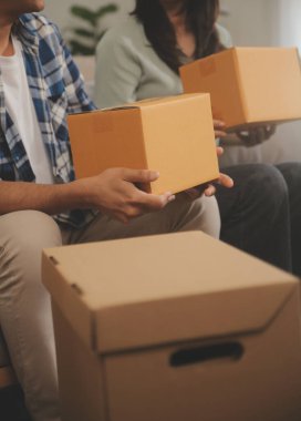 İki Asyalı blogcu, dükkanında canlı yayın yapan videoyu kaydetmek için kameranın önünde kıyafetlerini gösteriyor. Çevrimiçi alışveriş arabası fikri. Evdeki kanepede.