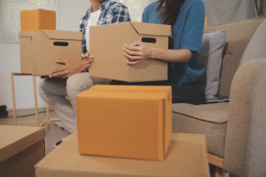 İki Asyalı blogcu, dükkanında canlı yayın yapan videoyu kaydetmek için kameranın önünde kıyafetlerini gösteriyor. Çevrimiçi alışveriş arabası fikri. Evdeki kanepede.