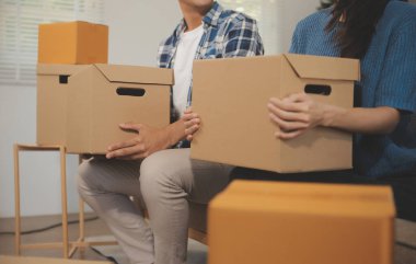 İki Asyalı blogcu, dükkanında canlı yayın yapan videoyu kaydetmek için kameranın önünde kıyafetlerini gösteriyor. Çevrimiçi alışveriş arabası fikri. Evdeki kanepede.