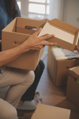 İki Asyalı blogcu, dükkanında canlı yayın yapan videoyu kaydetmek için kameranın önünde kıyafetlerini gösteriyor. Çevrimiçi alışveriş arabası fikri. Evdeki kanepede.