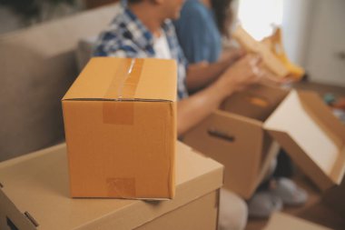 İki Asyalı blogcu, dükkanında canlı yayın yapan videoyu kaydetmek için kameranın önünde kıyafetlerini gösteriyor. Çevrimiçi alışveriş arabası fikri. Evdeki kanepede.