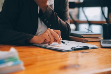 Ofiste dizüstü bilgisayarda çalışan Asyalı iş kadını masasında belgelerle mali raporu, iş planı yatırımını, mali analiz kavramını analiz etmeyi planlıyor.