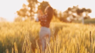 Buğday tarlasında genç bir kız. Gün batımı. Beyaz elbiseli genç kadın.