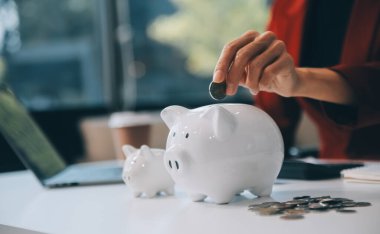 İş kadını domuz kumbarasından, hedeften, başarı grafiğinden ve oklardan tasarruf ediyor. Fon kredisi ve yatırım kârı. Sigorta, sağlık, eğitim, ev, araba, vergi, kredi için tasarruf kavramı