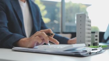 Emlakçı modern ofiste yeni bir kontrat üzerinde çalışıyor.