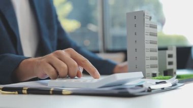 Emlakçı modern ofiste yeni bir kontrat üzerinde çalışıyor.