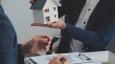 Emlakçı müşteri, sigorta ve emlak konsepti için yeni ev modeli gösteriyor