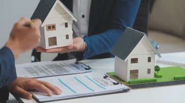 Emlakçı müşteri, sigorta ve emlak konsepti için yeni ev modeli gösteriyor
