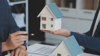 Emlakçı müşteri, sigorta ve emlak konsepti için yeni ev modeli gösteriyor