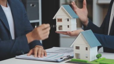 Emlakçı müşteri, sigorta ve emlak konsepti için yeni ev modeli gösteriyor