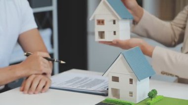 Emlakçı müşteri, sigorta ve emlak konsepti için yeni ev modeli gösteriyor