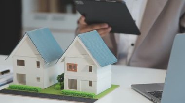Emlakçı müşteri, sigorta ve emlak konsepti için yeni ev modeli gösteriyor
