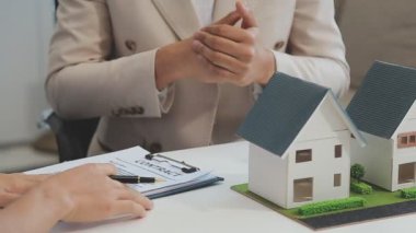 Emlakçı müşteri, sigorta ve emlak konsepti için yeni ev modeli gösteriyor