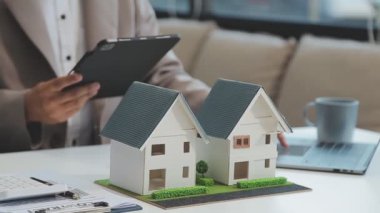 Emlakçı modern ofiste yeni bir kontrat üzerinde çalışıyor.