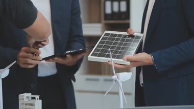 Yeşil bir firmadaki profesyoneller, modern binalar için çevre dostu enerji çözümleri yaratmak ve uygulamak için birlikte çalışıyorlar.